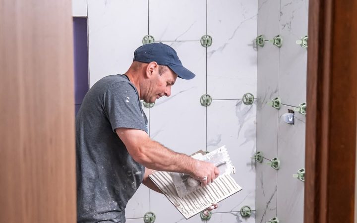 A close-up of a bathroom shower with gold hardware and marble tiles, showcasing the blend of functionality and style offered